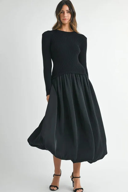 Model wearing black long sleeve ribbed sweater dress with full poplin midi skirt
