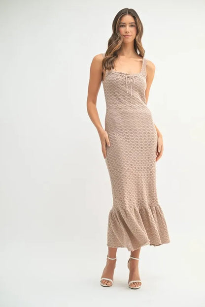 Model wearing neutral crochet knit midi dress with sleeveless design and ruffled hem


