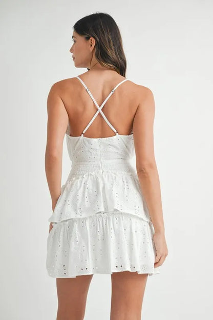 Back view of ruffle mini dress with open back and crisscross straps in white eyelet lace
